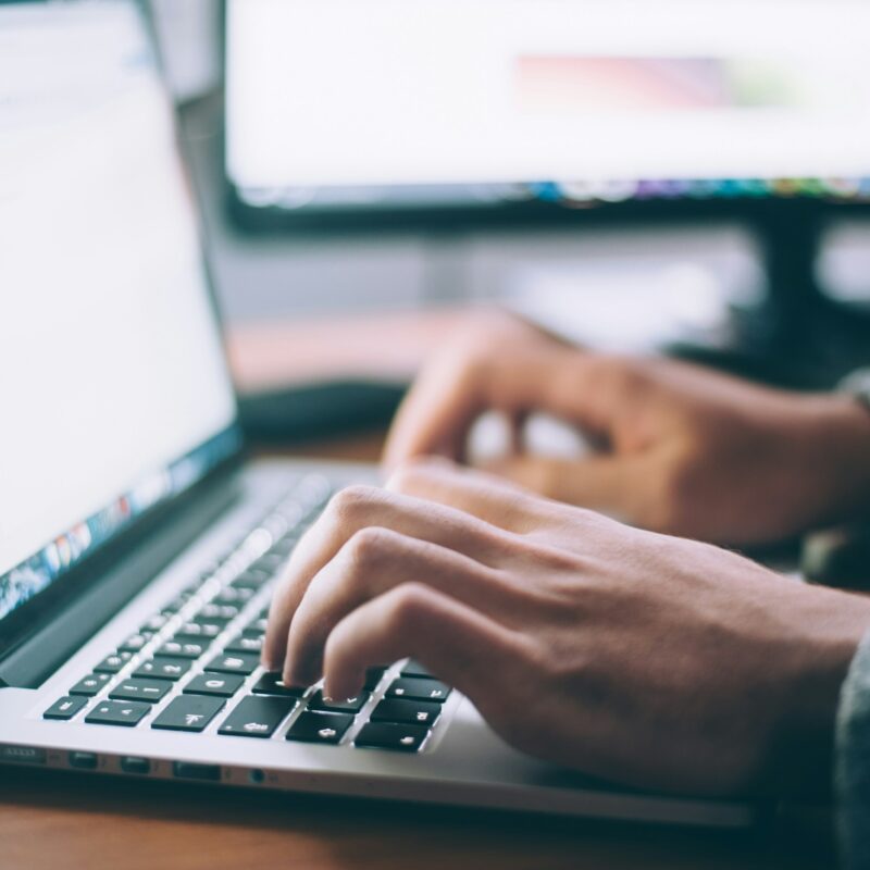 hands typing on laptop